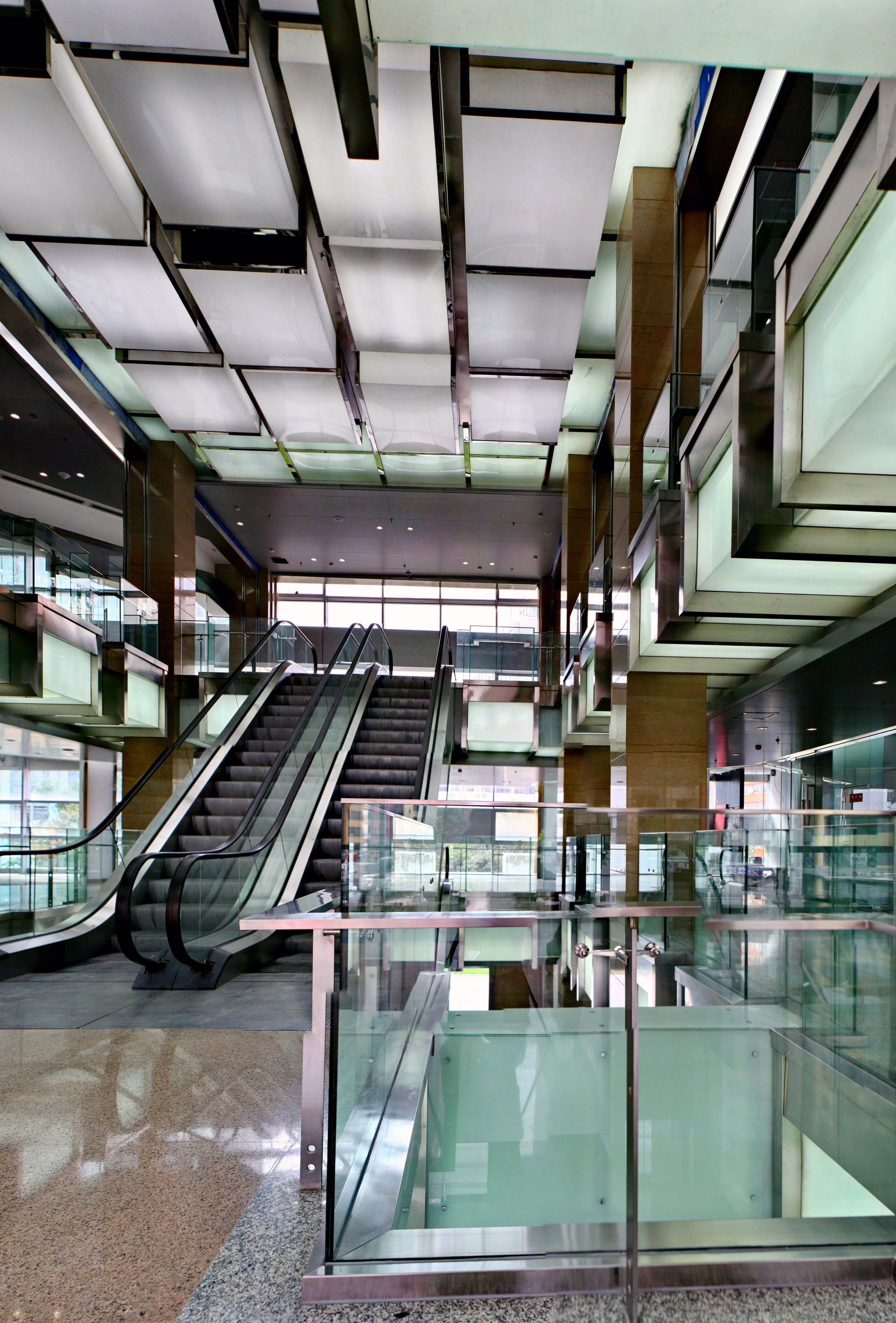 A narrow atrium turned luminous with glass, steel and light